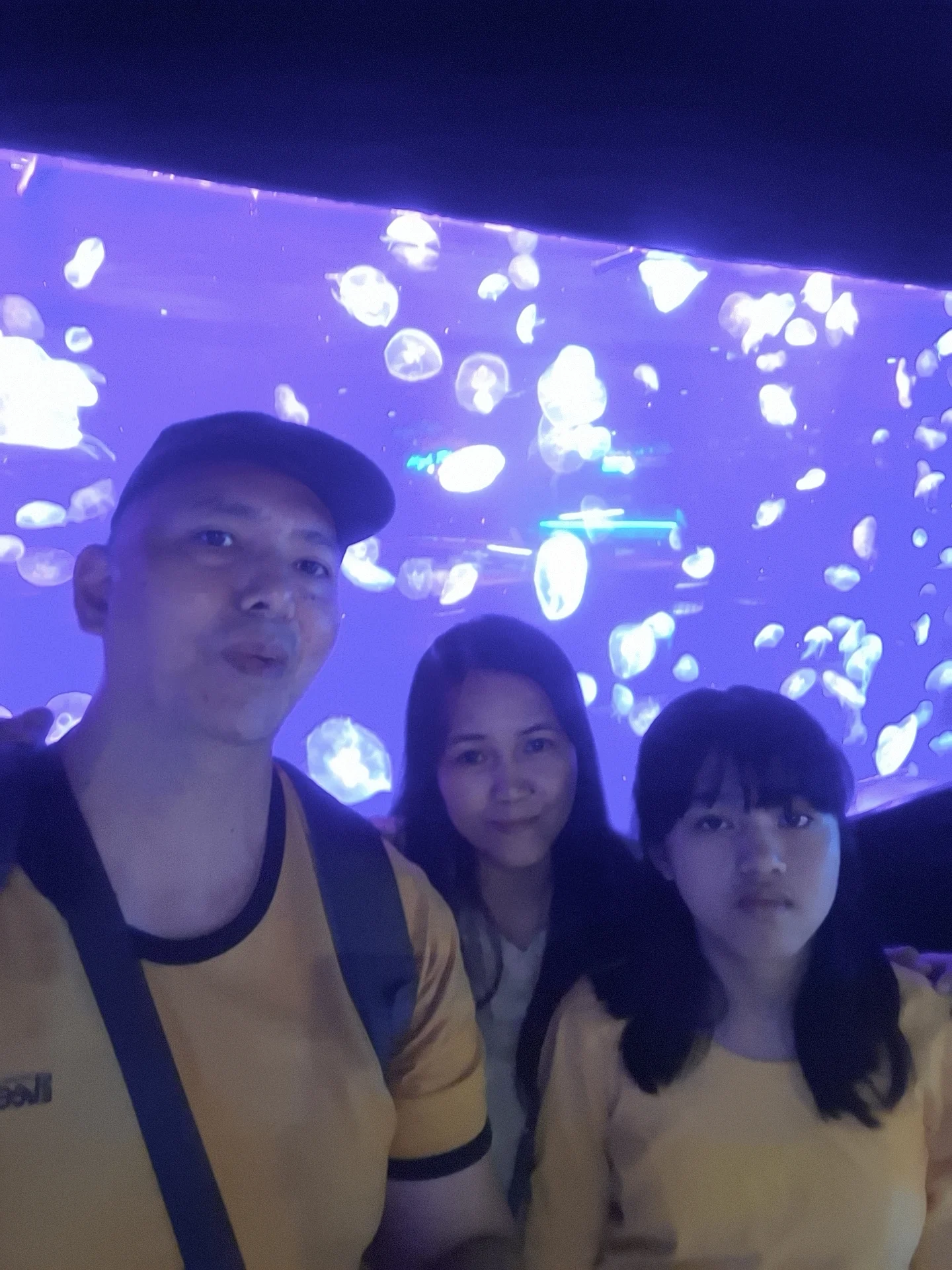 Giovanni Carlo Bagayas and family taking a selfie in front of a glowing jellyfish tank display at Cebu Ocean Park