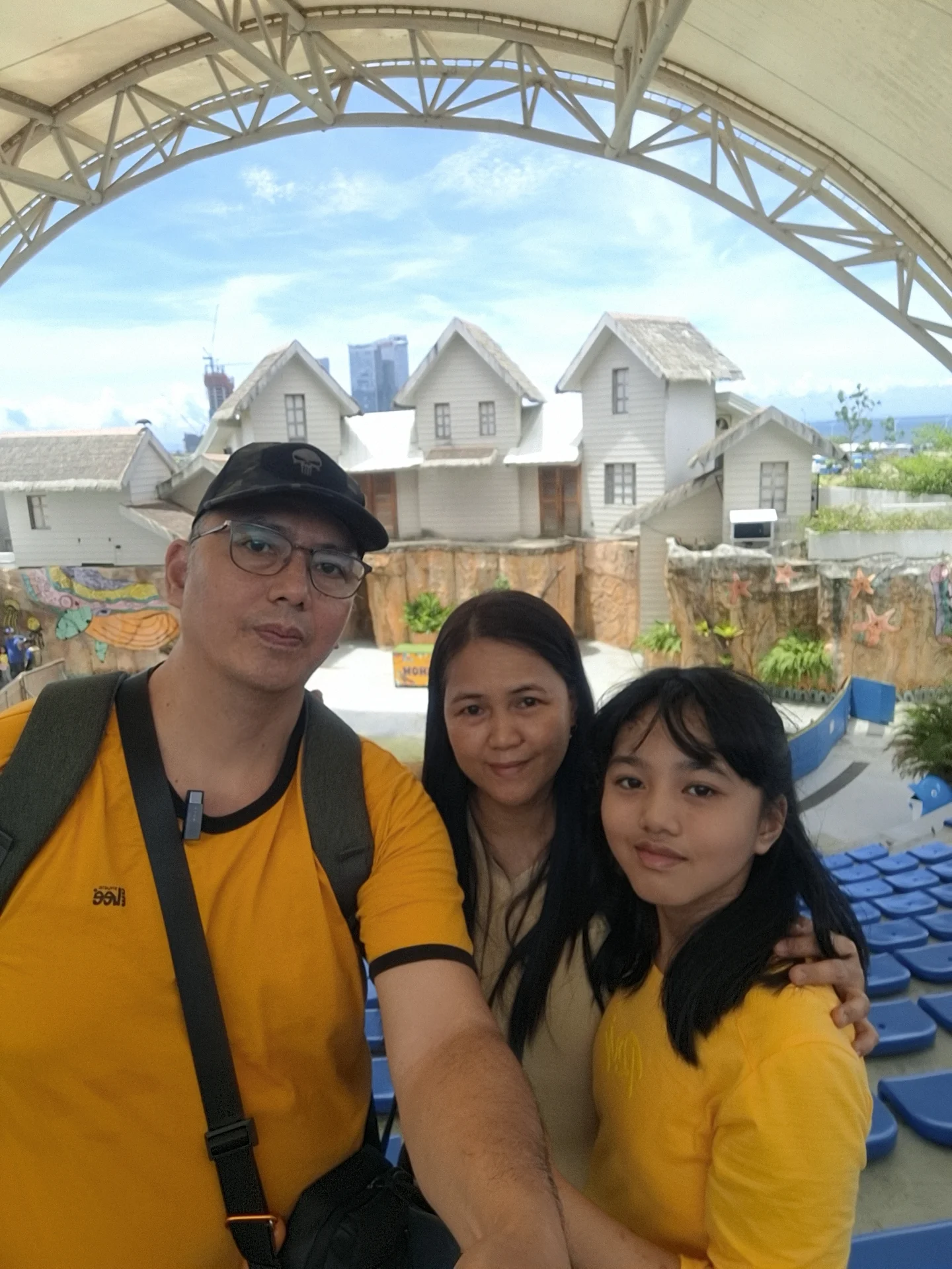 Giovanni Carlo Bagayas and family posing in front of the colorful rooftop village backdrop at Cebu Ocean Park