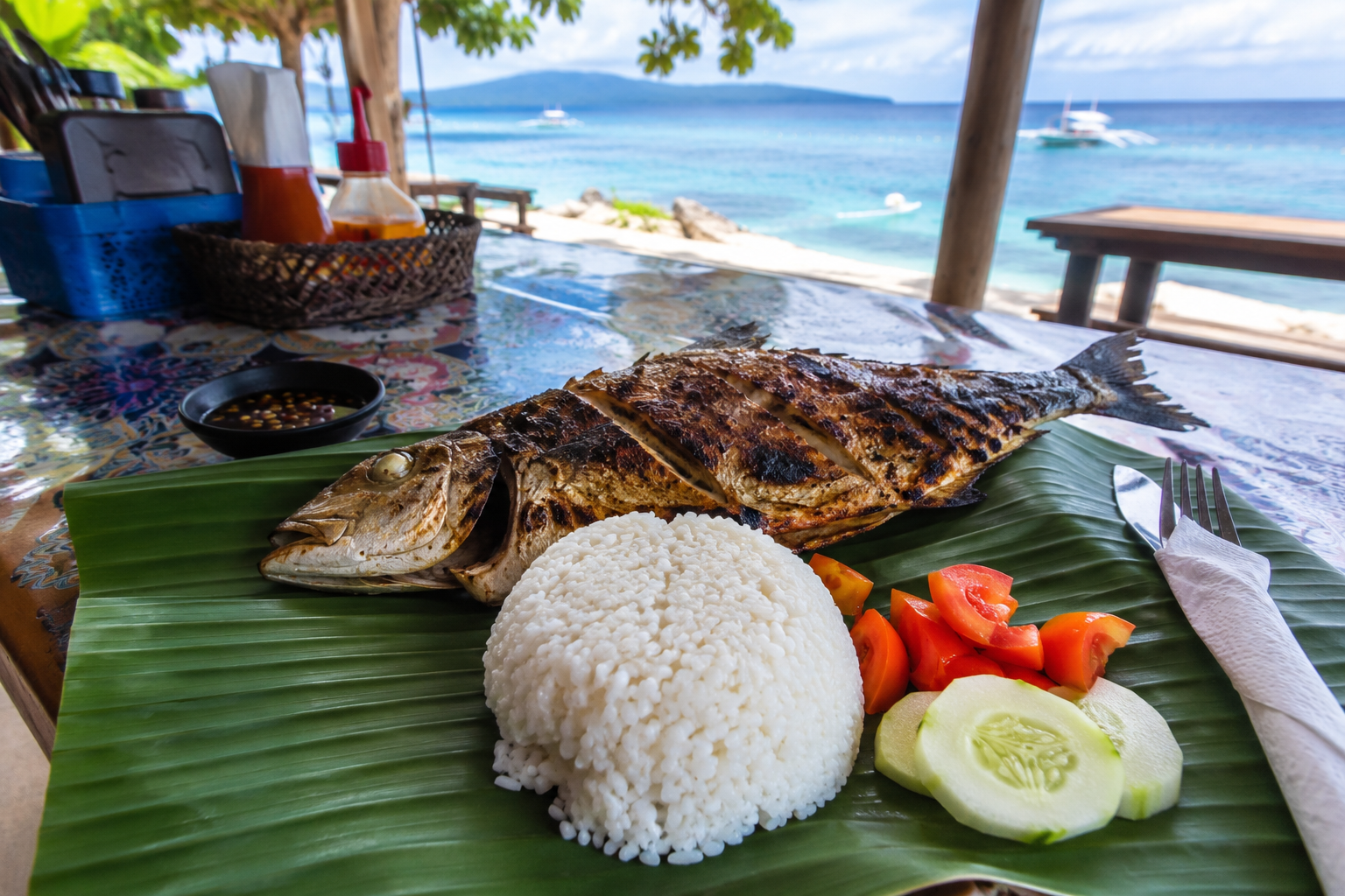 Fresh grilled fish lunch served on a banana leaf at an Apo Island beachside eatery — sustainably caught outside the marine sanctuary Philippines