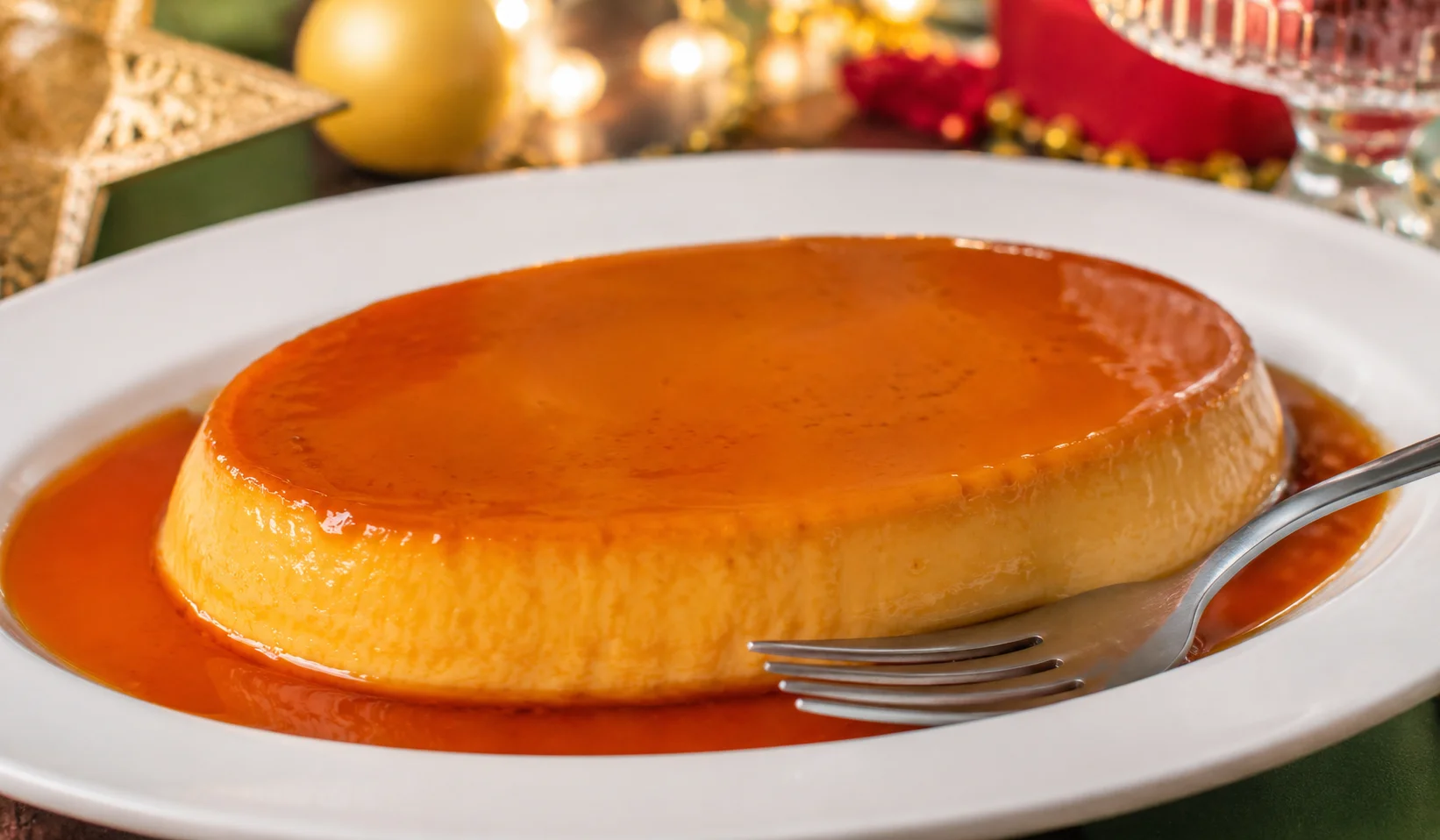 Leche flan Filipino birthday dessert — golden caramel custard unmolded from its llanera onto a white plate, with amber caramel sauce pooling around the smooth silky surface