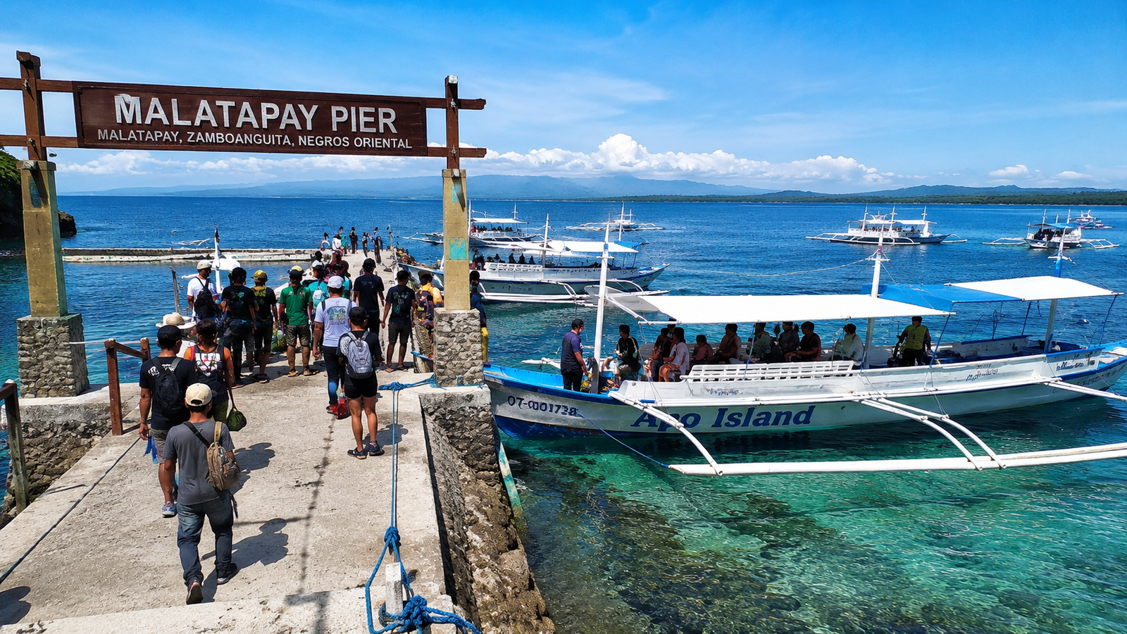 Malatapay pier with bangka outrigger boats lined up ready to depart for Apo Island — passengers boarding at the Zamboanguita boat terminal Negros Oriental Philippines
