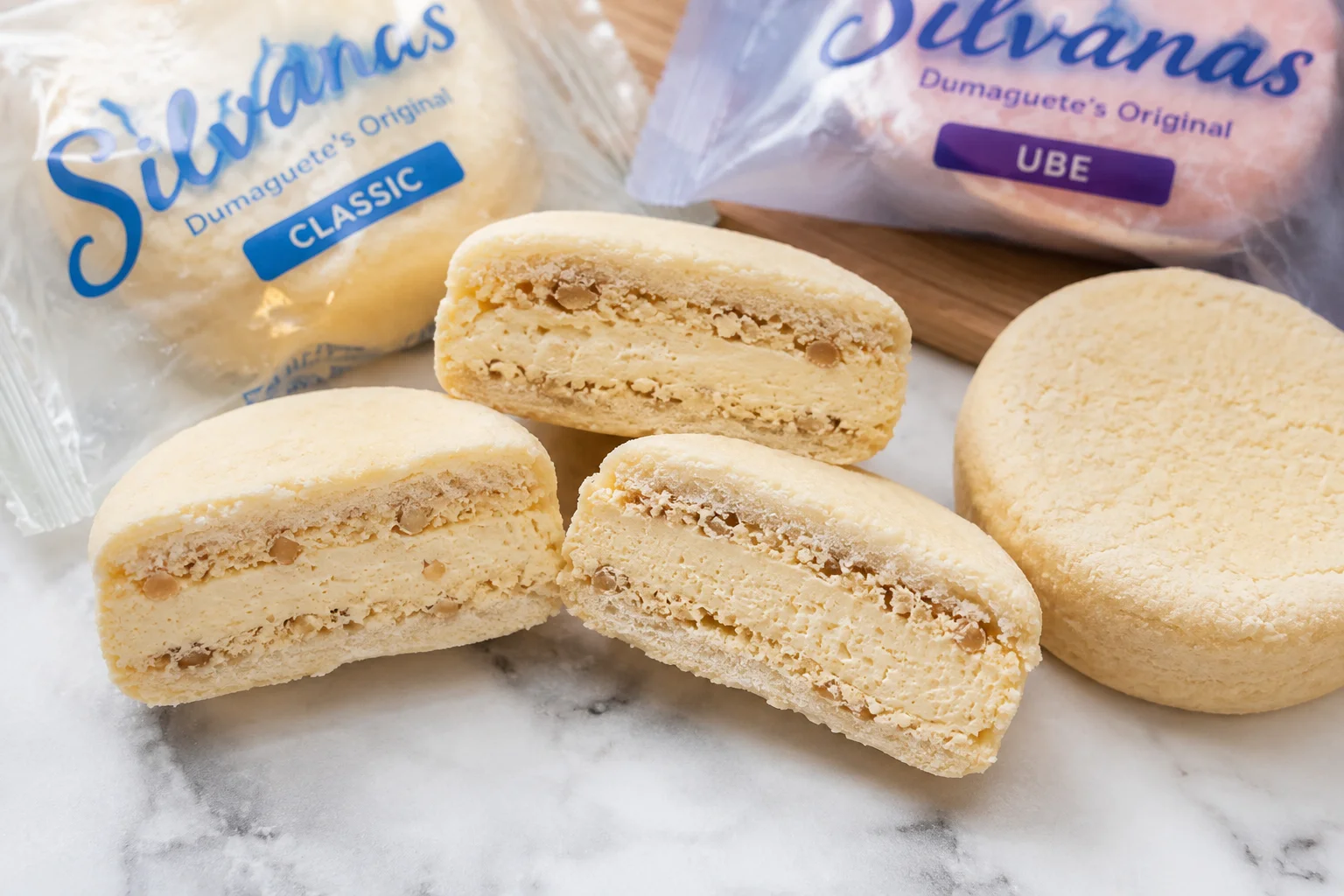 Silvanas cut in half showing the cashew meringue wafer layers and French buttercream filling — Dumaguete's most iconic food gift (pasalubong), sold at Sans Rival Cakes and Pastries on Rizal Boulevard