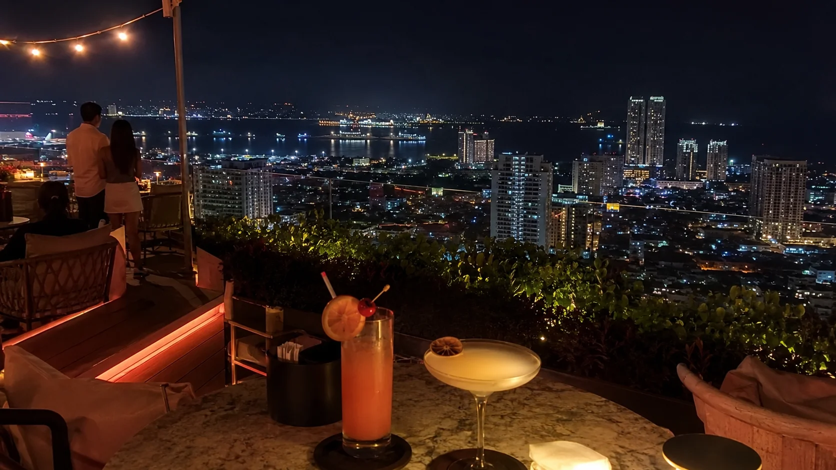 Rooftop bar in Cebu City at night with skyline view and cocktails