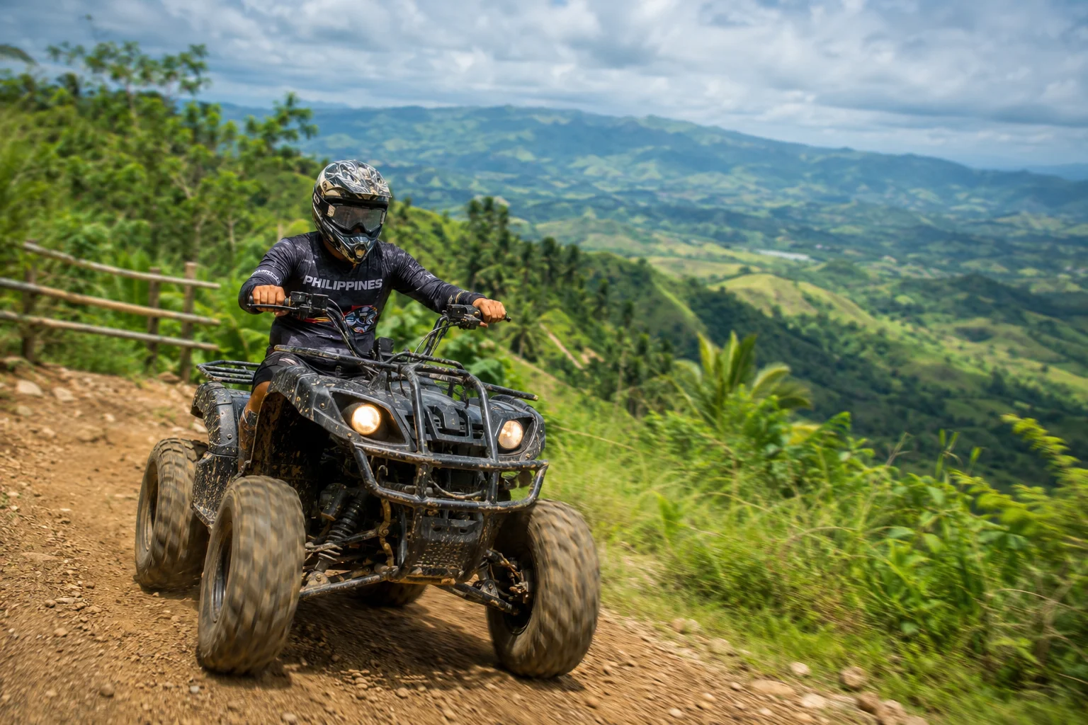 ATV all-terrain vehicle rider on a rugged mountain trail at Cebu Safari and Adventure Park with green mountain scenery in background