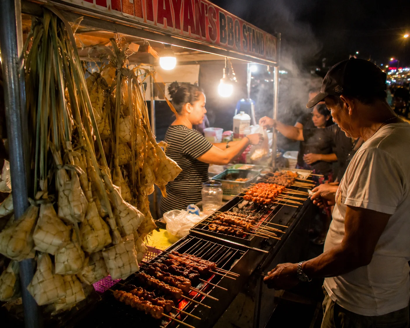 Grilled BBQ skewers and hanging rice puso at a Cebu street food stall