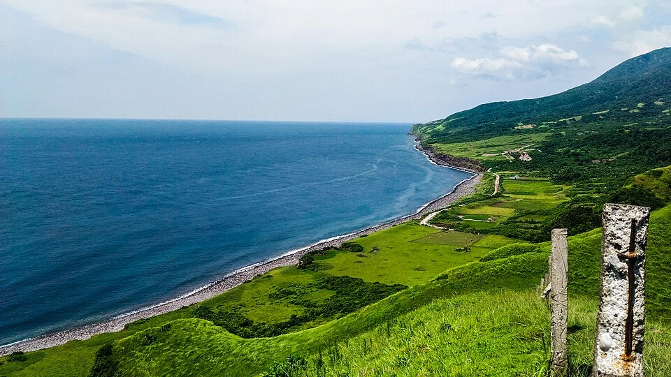 10 Romantic Getaways in the Philippines (2026): Best Honeymoon Spots for Couples 17 Rolling green hills above the sea in Batanes